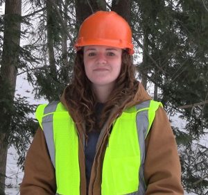 photo of Sydney Andersen outside in a forest wearing a helmet and safety vest